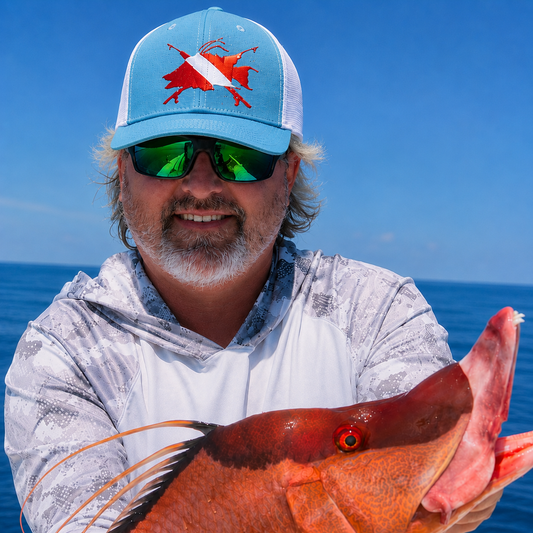 Model wearing a hogfish trucker hat in light blue. Holding a hogfish on a boat in the Atlantic ocean