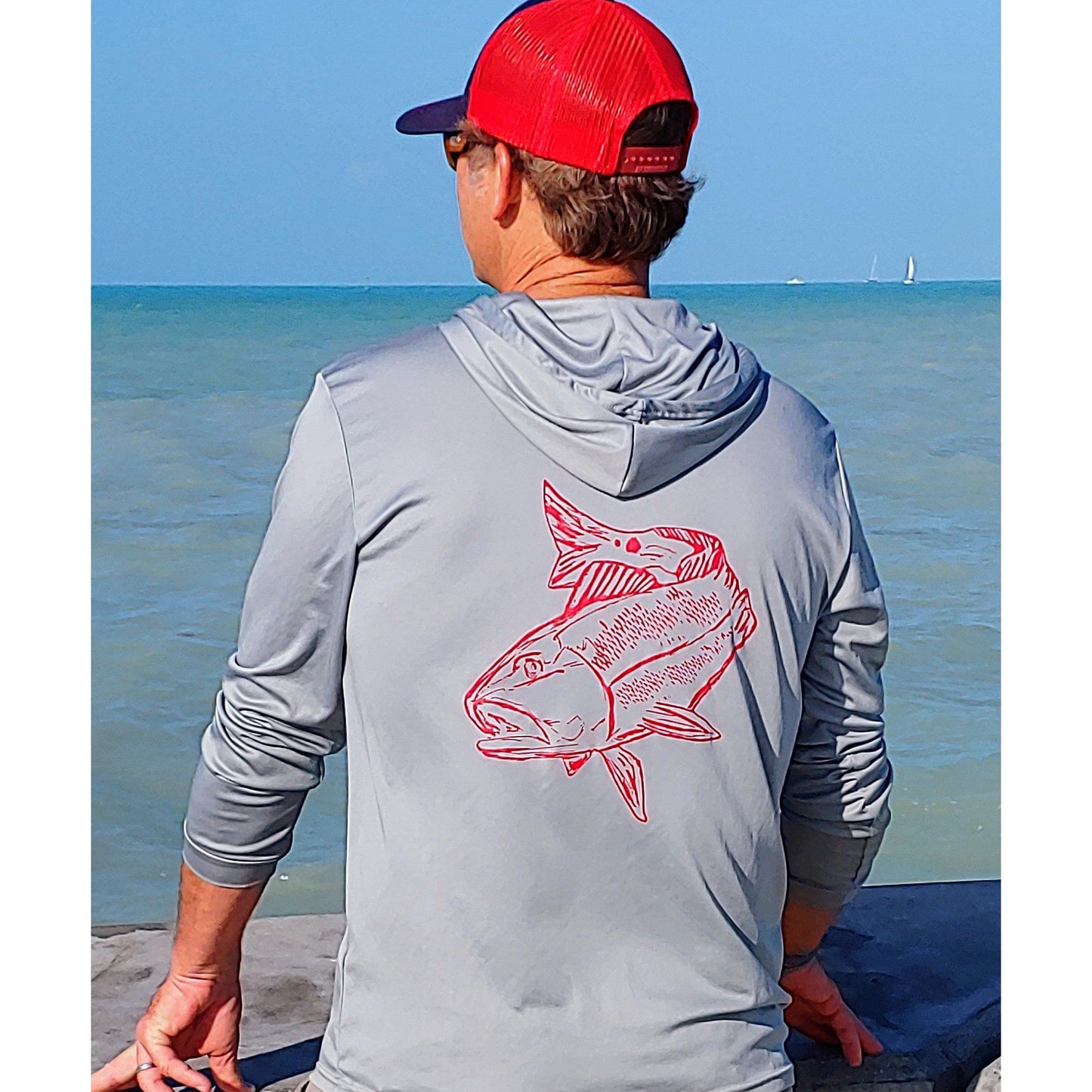 Model wearing light gray Redfish dri-fit 50+ sun protection short sleeve hoodie