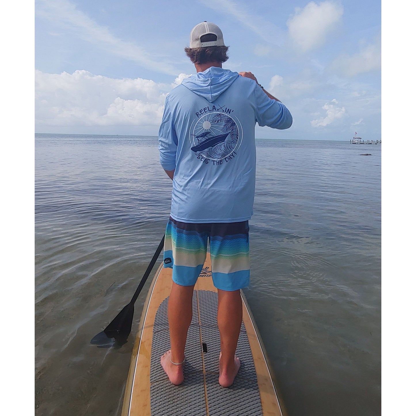 Model wearing light blue Reelaxin' Seas the Day dri-fit 50+ sun protection long sleeve hoodie