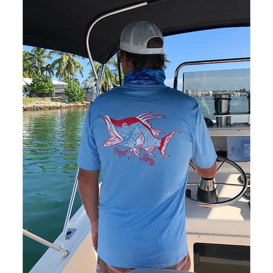 Model wearing light blue short sleeve shirt with hogfish graphic and 50+ UV protection by Reel Fishy Apparel.