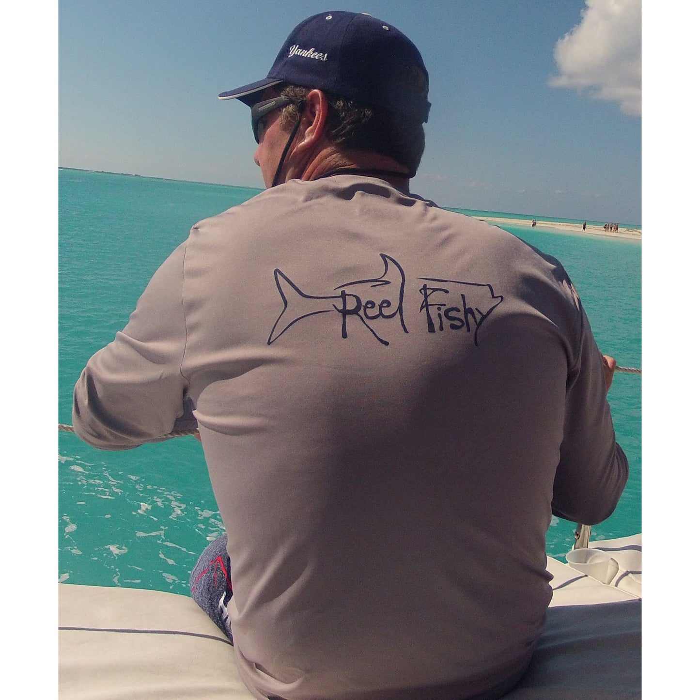 Model wearing a gray long sleeve Reel Fishy Tarpon Fishing Dri-Fit shirt with 50+UPF sun protection.