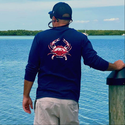 Model in navy long sleeve Reel Crabby performance shirt featuring blue crab design with 50+ UPF sun protection