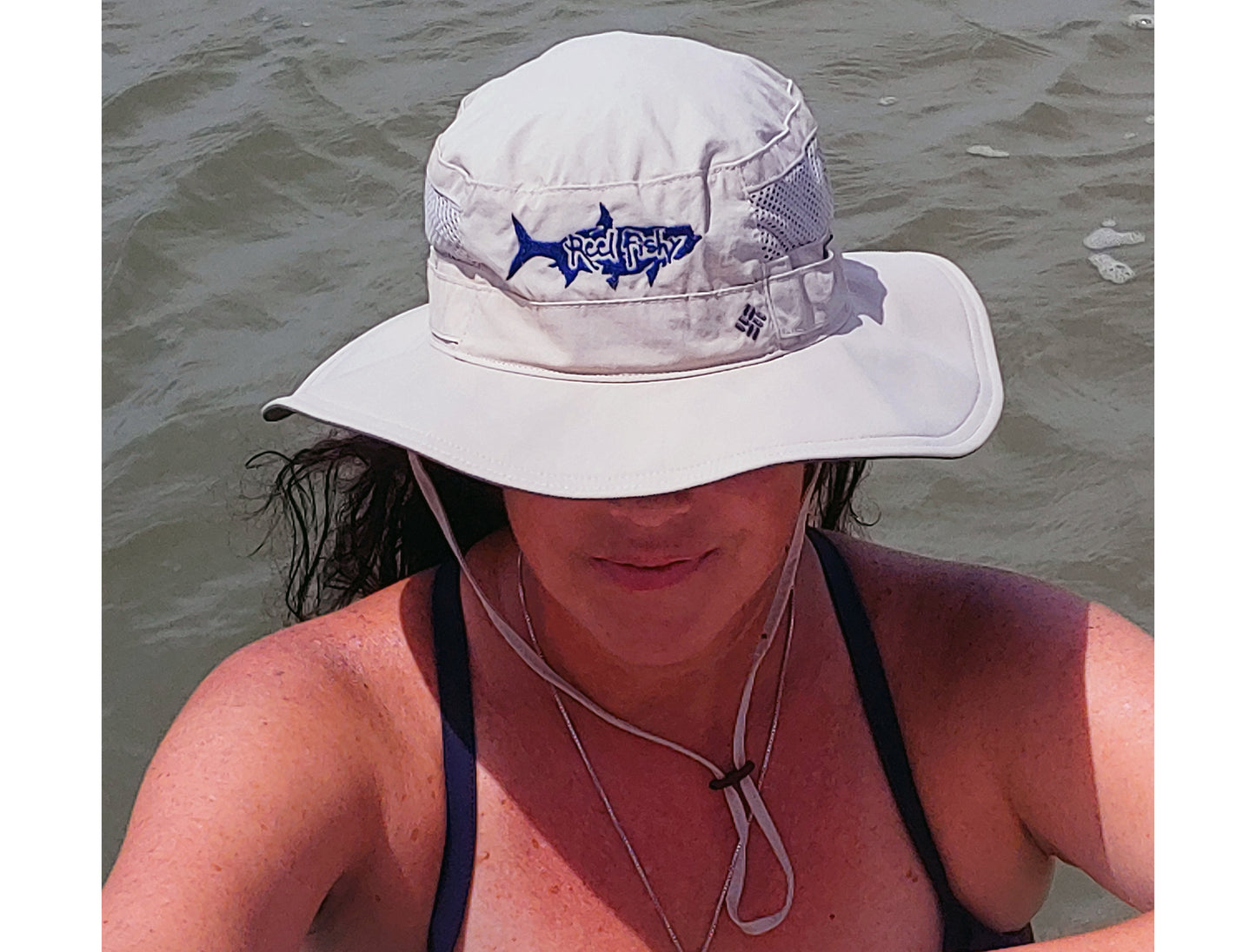 Model wearing tan boonie fishing hat with tarpon logo, 30+ UPF sun protection.