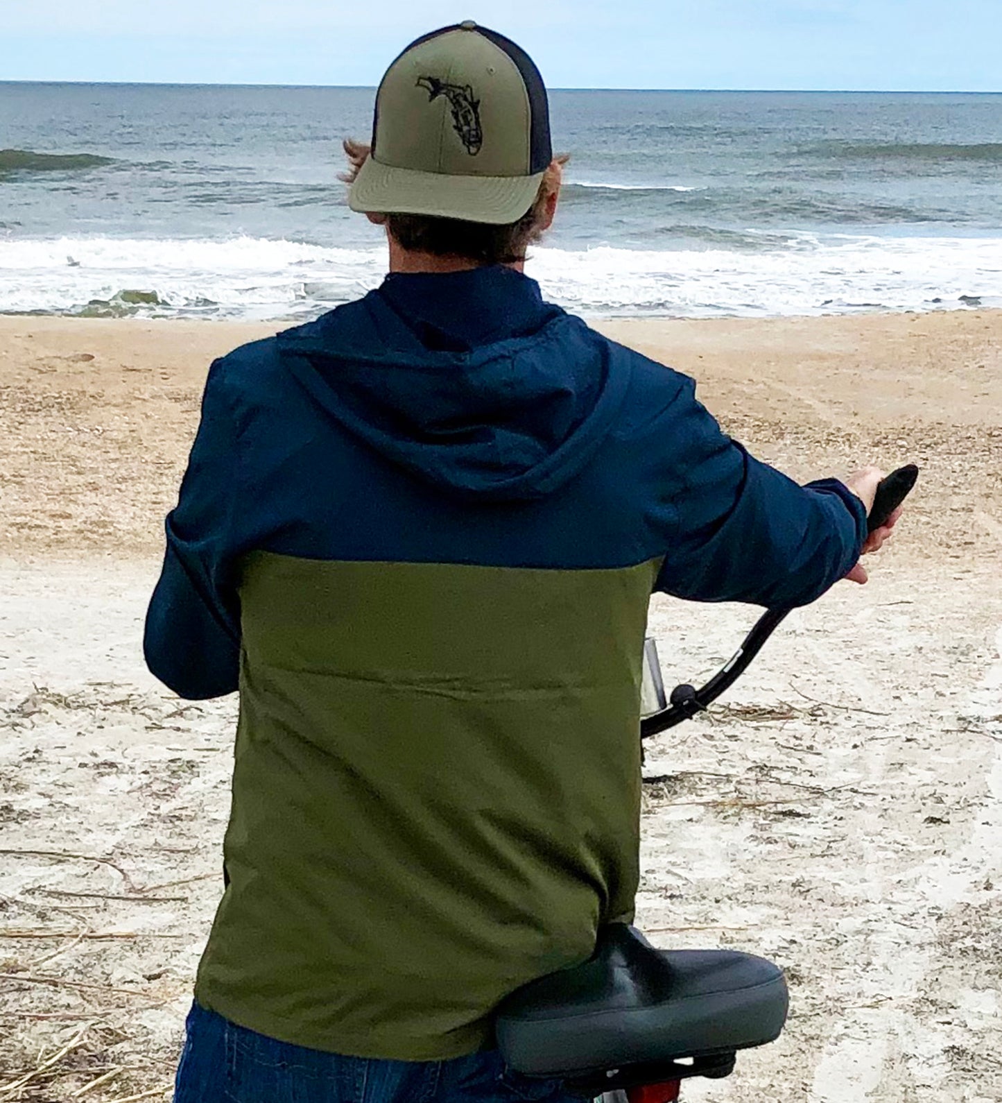 Model wearing Navy/Army lightweight windbreaker jacket with hood, water resistant, full zip front closure