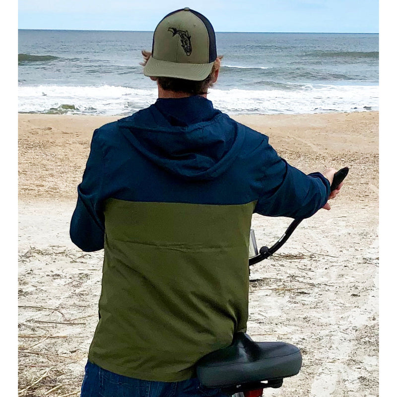 Model wearing Navy/Army lightweight windbreaker jacket with hood, water resistant, full zip front closure