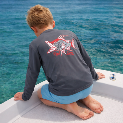 Child sitting on a boat looking at the ocean wearing a gray long sleeve performance sun shirt with a hogfish design and the text "Reel Hog".