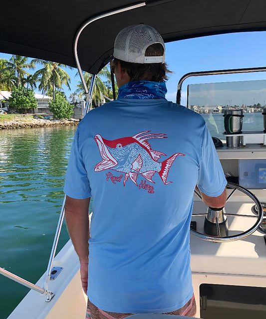 Model wearing light blue short sleeve shirt with hogfish graphic and 50+ UV protection by Reel Fishy Apparel.