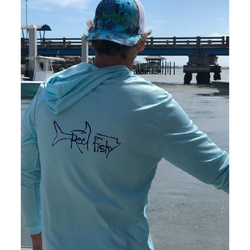 Model wearing light blue Reel Fishy Tarpon performance fishing hoodie with long sleeves and 50+ UPF sun protection