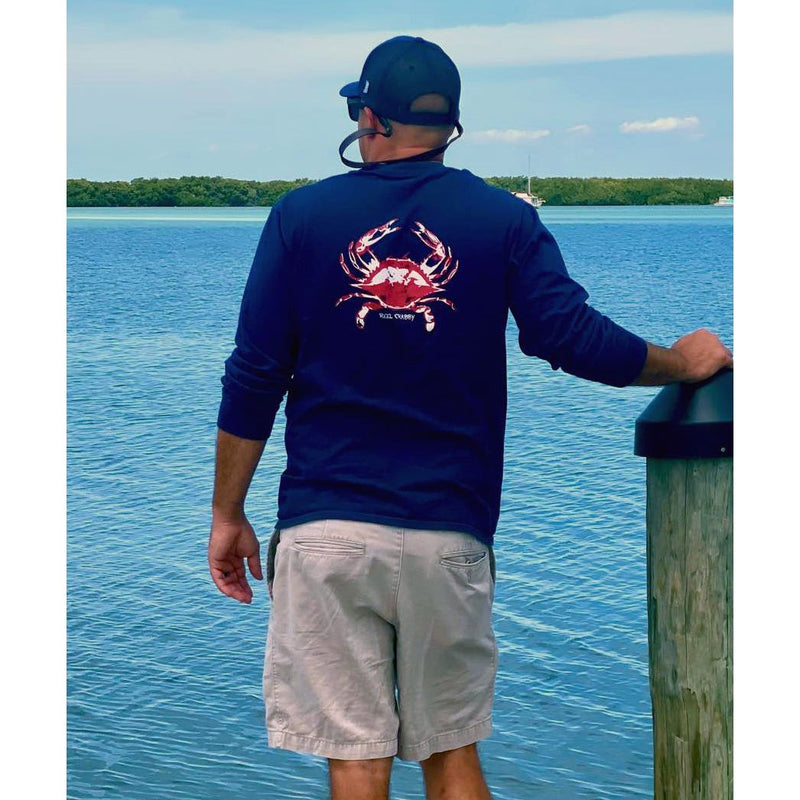 Model in navy long sleeve Reel Crabby performance shirt featuring blue crab design with 50+ UPF sun protection
