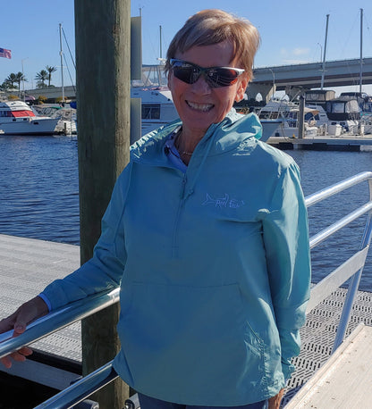 Model wearing Reel Fishy 1/2-Zip Pullover Windbreaker Jacket in Aqua Blue with Tarpon embroidery logo